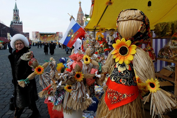 People view straw effigies for sale at a booth just outside the Kremlin